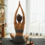 person meditating near window