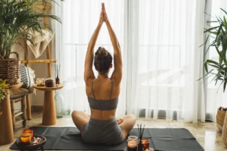 person meditating near window