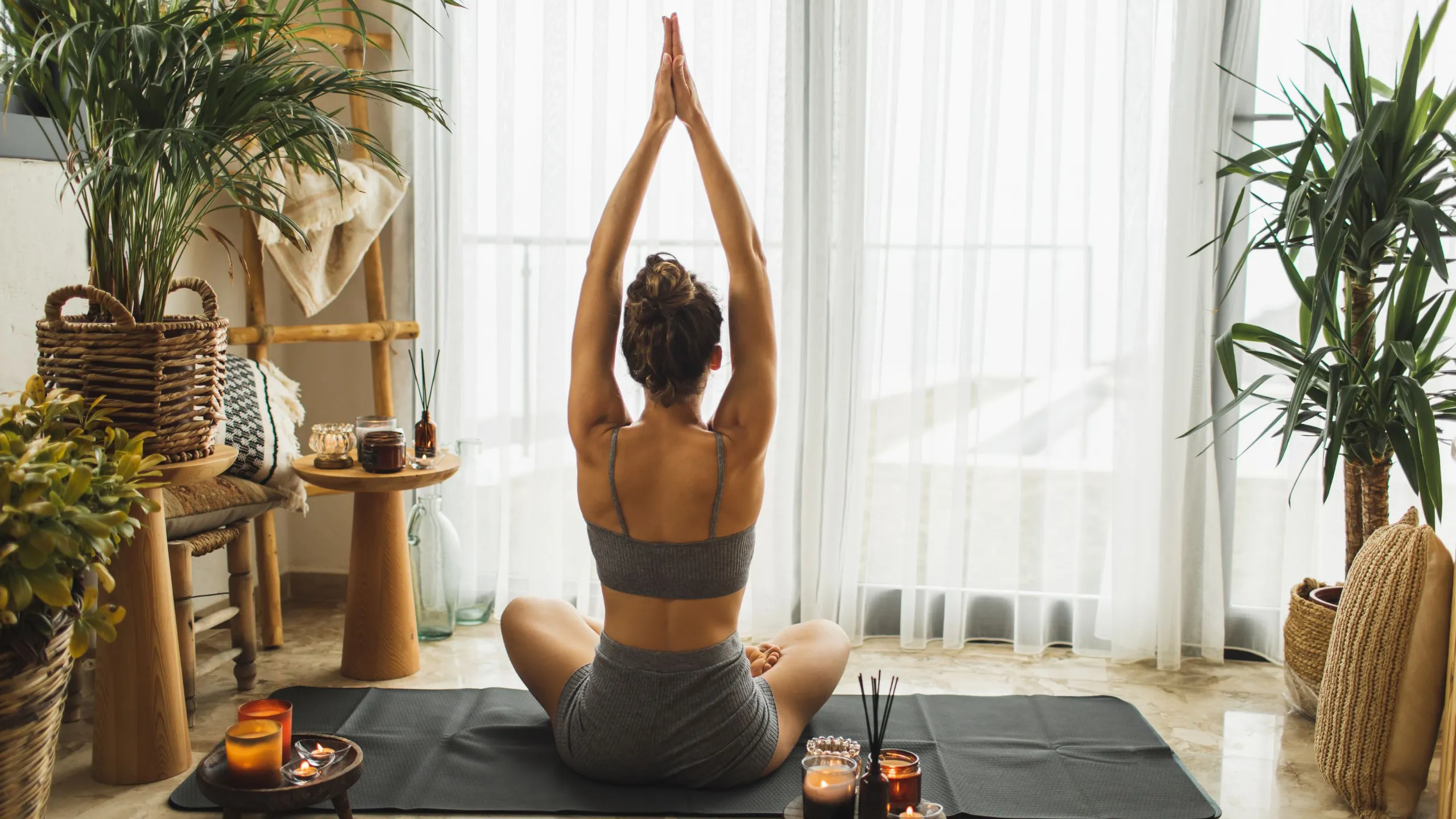 person meditating near window