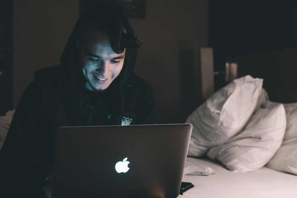 person smiling at laptop