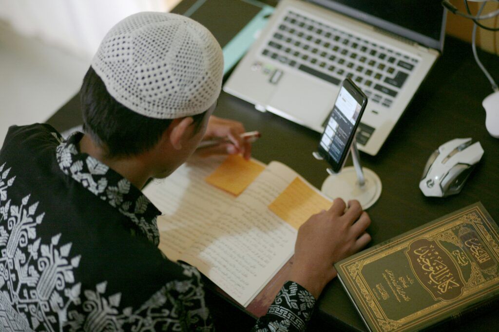 person studying with phone and notebook